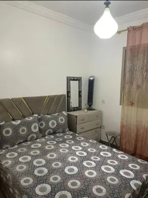 a bedroom with a bed and a dresser with a mirror at Appart in Marrakech 5G in Marrakech