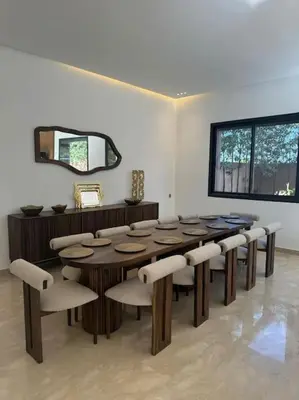 a dining room with a table and chairs and a mirror at Sublime Villa avec Ascenseur Piscine chauffée in Marrakech