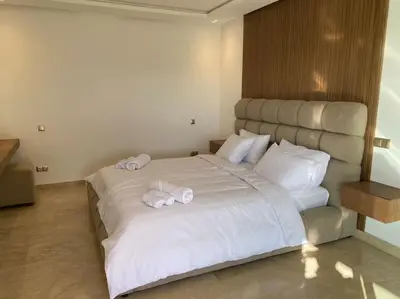 a bedroom with a large white bed with towels on it at Sublime Villa avec Ascenseur Piscine chauffée in Marrakech