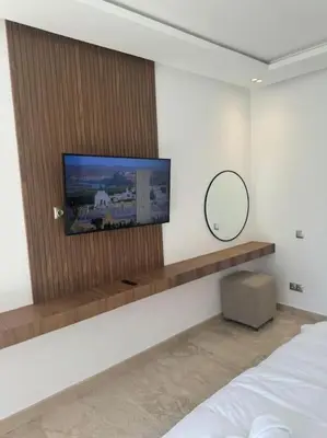 a bedroom with a flat screen tv on a wall at Sublime Villa avec Ascenseur Piscine chauffée in Marrakech