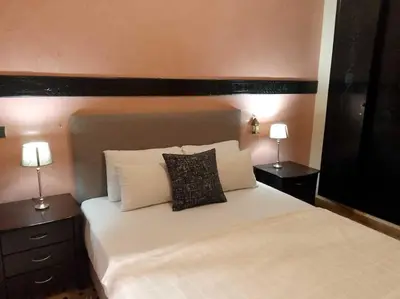 a bedroom with a large white bed with two lamps at Cosy Apartment with 5 pools in Marrakech