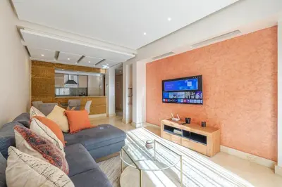 a living room with a couch and a tv on a wall at Best location new appart café de la poste Plaza in Marrakech