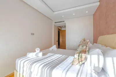 a bedroom with a white bed in a room at Best location new appart café de la poste Plaza in Marrakech