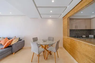 a living room with a table and a couch at Best location new appart café de la poste Plaza in Marrakech