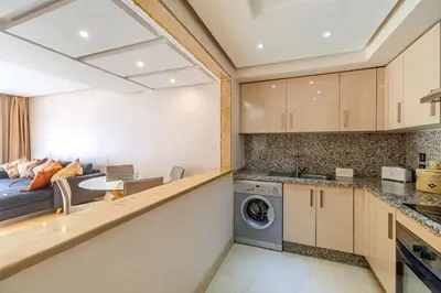 a kitchen and living room with a washer and dryer at Best location new appart café de la poste Plaza in Marrakech