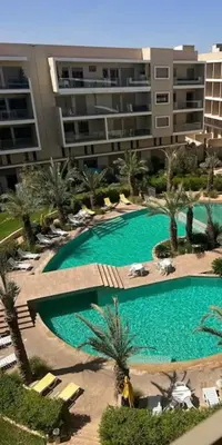 an overhead view of a large swimming pool with palm trees at Bonjour cher client in Marrakech