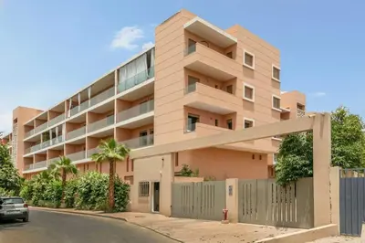 an apartment building with a fence in front of it at Bonjour cher client in Marrakech