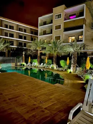 a hotel with a swimming pool in front of a building at Bonjour cher client in Marrakech
