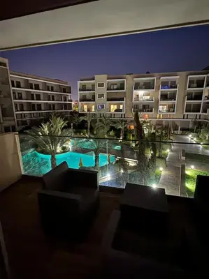 a view of a hotel with a swimming pool at night at Bonjour cher client in Marrakech