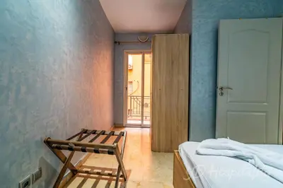 a bedroom with a bed and a chair and a door at 5-Star Atlas Pearl well Centered in Marrakech