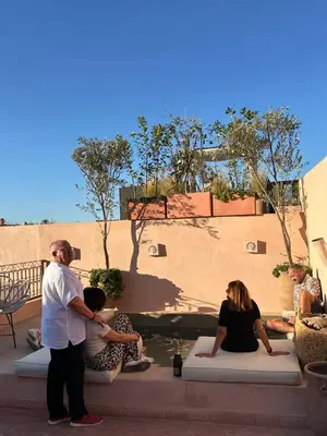 a group of people sitting on steps in front of a building at Le RIAD Paradis Secret in Marrakech