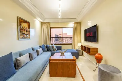 a living room with a blue couch and a tv at Coup de coeur en plein centre ville piscine in Marrakech