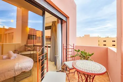 a room with a bed and a table on a balcony at Coup de coeur en plein centre ville piscine in Marrakech