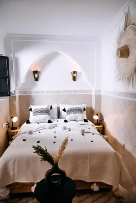 a bedroom with a large bed in a room with lights at Riad Tawkane in Marrakech