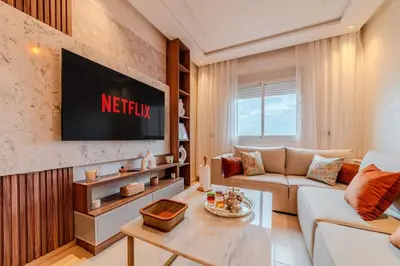 a living room with a couch and a tv on a wall at 2Br Apartment 15 min from Jemaa el-Fnaa Marrakech in Marrakech