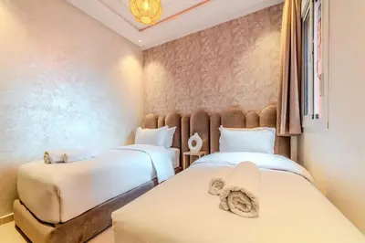 a room with two beds with white sheets at 2Br Apartment 15 min from Jemaa el-Fnaa Marrakech in Marrakech