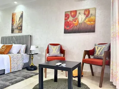 a living room with a bed and two chairs and a table at Maison du Bonheur à Marrakech in Marrakech