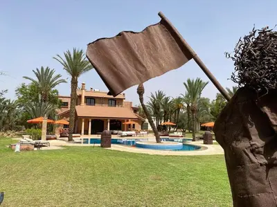 a statue in front of a house with a pool at Villa jowehara Palmeraie Marrakech in Marrakech
