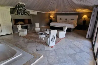 a large bedroom with a bed and a tub at Villa jowehara Palmeraie Marrakech in Marrakech