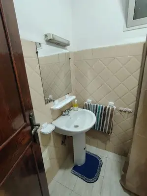 a small bathroom with a sink and a mirror at Quiet and family apartment, appartement in Marrakech