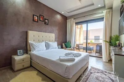 a bedroom with a large bed and a balcony at 5-Star Suite in Prime Spot with Luxe Touches in Marrakech