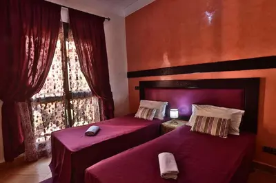 two beds in a room with a window at Amazing view, apartment in Marrakech in Marrakech