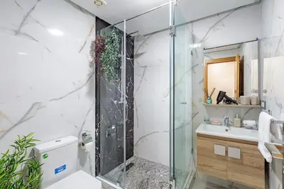 a bathroom with a glass shower and a sink at Charm Apt dans le triangle Tourisme de Marrakech ! in Marrakech