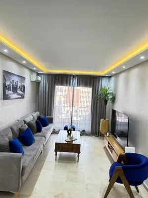 a living room with a couch and a tv at Appart au Cœur de Gueliz in Marrakech