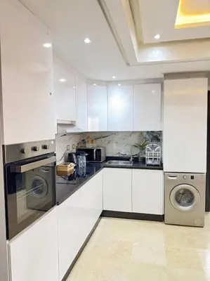 a kitchen with white cabinets and a washer and dryer at Appart au Cœur de Gueliz in Marrakech