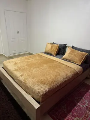 a bed with a wooden frame in a room at calme est spacieux 37 pour les familles in Marrakech