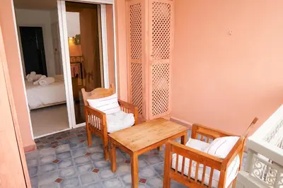 a porch with a wooden table and chairs and a mirror at Suite Majorelle - Luxe-Terasse-Parking privée in Marrakech