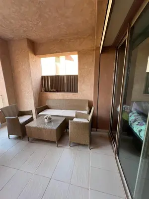 a room with a table and chairs and a bed at Appartement de luxe Prestigia in Marrakech