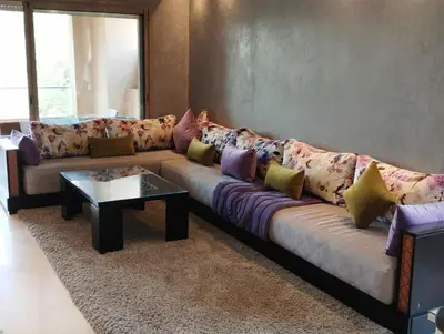 a living room with a couch with colorful pillows at Appartement de luxe Prestigia in Marrakech