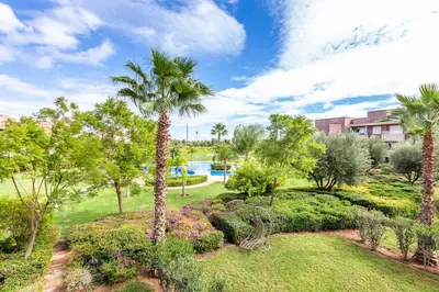 a garden with palm trees and a swimming pool at Stunning Prestigia Escape Poolside Views in Marrakech