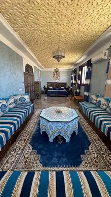 a living room with two couches and a table at Dar Yamna Maison d'Hôtes in El Gouassem