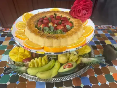 a cake on top of a table with fruit at Dar Yamna Maison d'Hôtes in El Gouassem