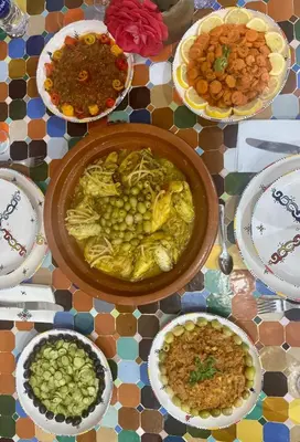 a table with plates of food and a bowl of food at Dar Yamna Maison d'Hôtes in El Gouassem