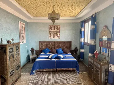 a bedroom with a bed with blue walls and a ceiling at Dar Yamna Maison d'Hôtes in El Gouassem