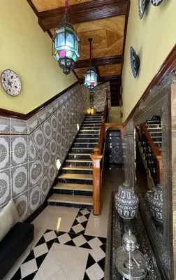 a hallway with stairs and a chandelier at Dar Yamna Maison d'Hôtes in El Gouassem