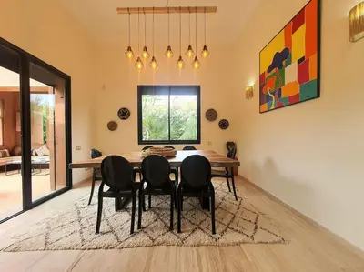 a dining room with a table and chairs at Villa avec piscine chauffée en option Palmeraie in Marrakech