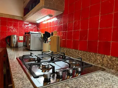 a stove top in a kitchen with red tiles at Villa avec piscine chauffée en option Palmeraie in Marrakech