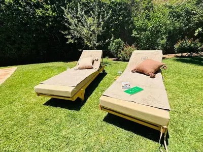 two beds sitting on the grass in a yard at Villa avec piscine chauffée en option Palmeraie in Marrakech