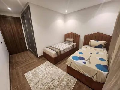 a small bedroom with two beds and a rug at Élégance urbaine, Gueliz central in Marrakech