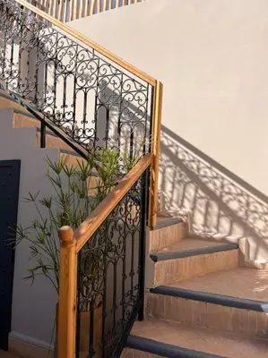 a staircase with a wrought iron railing and a plant at Riad Dar Fannan en exclusivité in Marrakech
