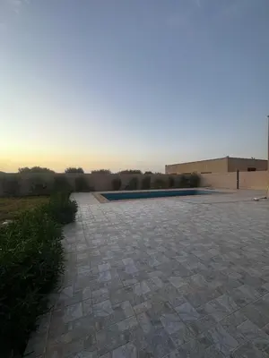 a stone courtyard with a pool in the background at Villa S in Marrakech