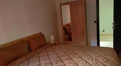 a bedroom with a large bed with a wooden head board at appartement Nizar in Marrakech