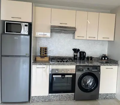 a kitchen with a refrigerator and a washing machine at Chambre de luxe avec piscine in Marrakech