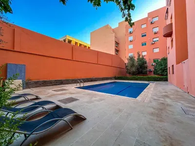 a swimming pool in a courtyard next to a building at Luxoria Home - Pool & 3 min To Gueliz in Marrakech