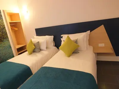 two twin beds in a hotel room withwered at Hotel Relax Marrakech in Marrakech