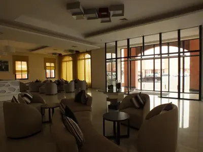 a lobby with couches and tables and windows at Hotel Relax Marrakech in Marrakech